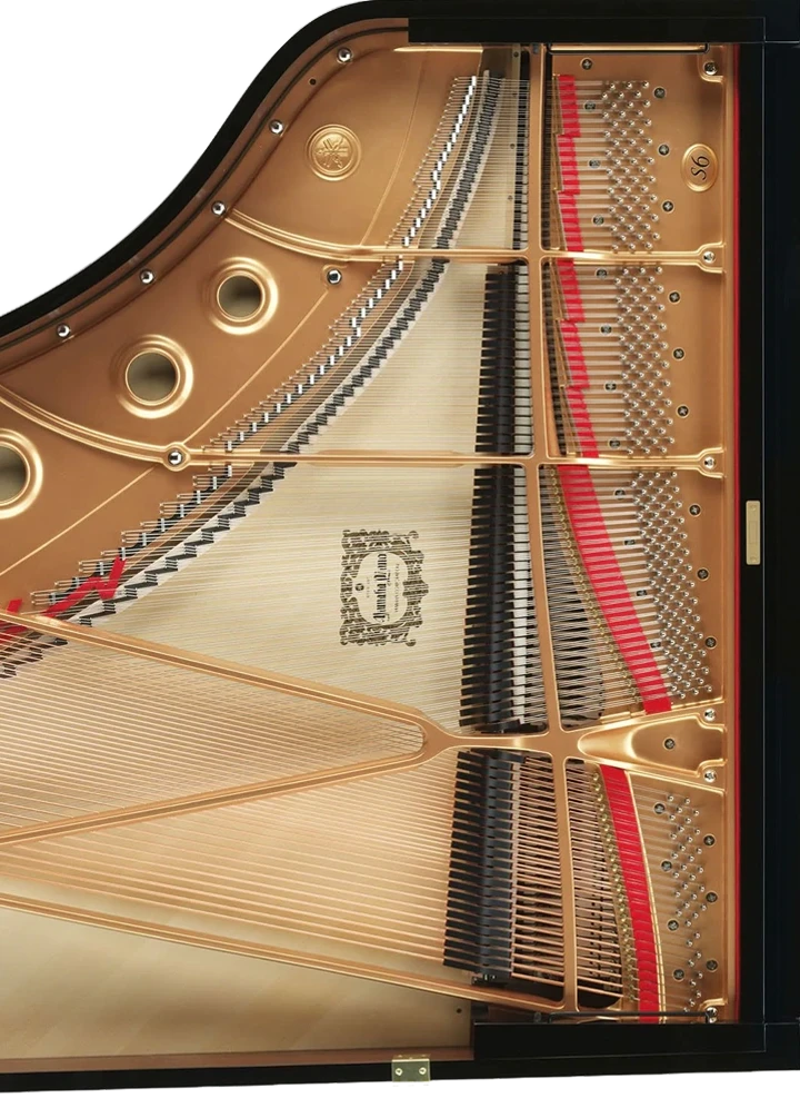image of a grand piano from above without the lid revealing the strings and the sound board